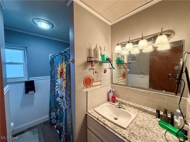 bathroom featuring crown molding, vanity, and decorative backsplash