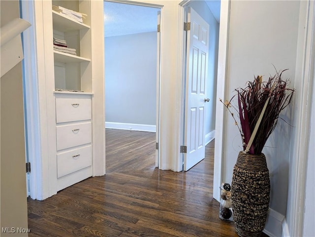 hall with built in features and dark hardwood / wood-style floors