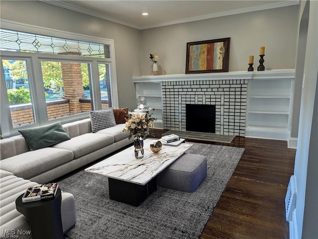 living room featuring dark wood-type flooring, crown molding, and a tile fireplace