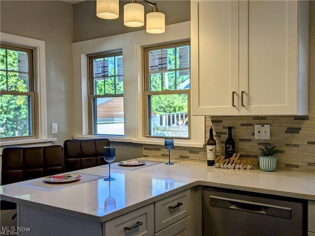 kitchen with dishwashing machine, hanging light fixtures, tasteful backsplash, light stone countertops, and white cabinets