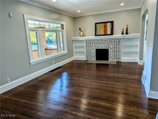 unfurnished living room featuring a tiled fireplace, crown molding, and dark wood-type flooring