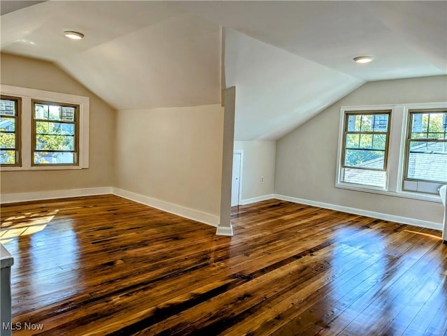 additional living space with baseboards, lofted ceiling, and hardwood / wood-style flooring