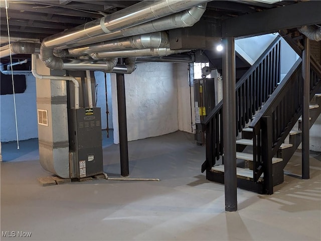 unfinished below grade area with stairway, heating unit, and water heater