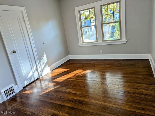 unfurnished bedroom with dark hardwood / wood-style flooring