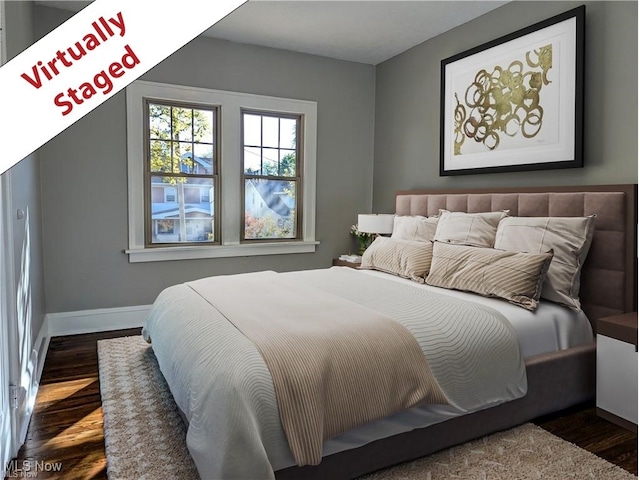 bedroom featuring baseboards and wood finished floors