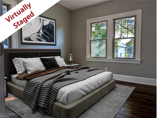 bedroom featuring baseboards and wood finished floors
