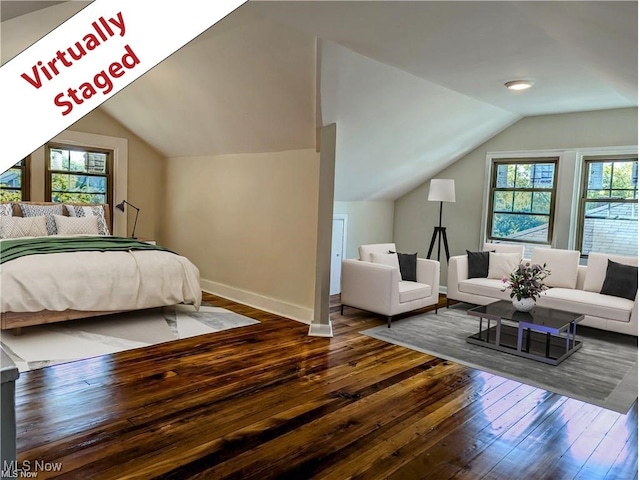 bedroom with baseboards, vaulted ceiling, multiple windows, and hardwood / wood-style floors