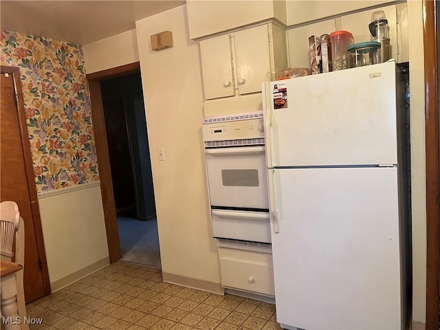 kitchen with white appliances and white cabinets