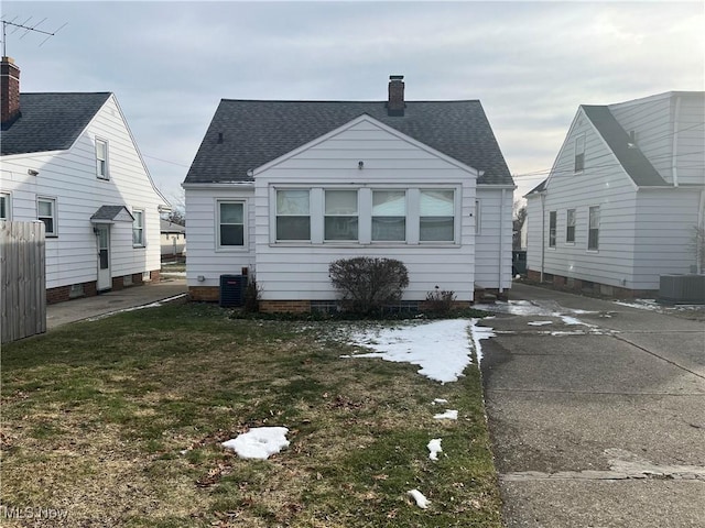 back of house with a lawn and central air condition unit