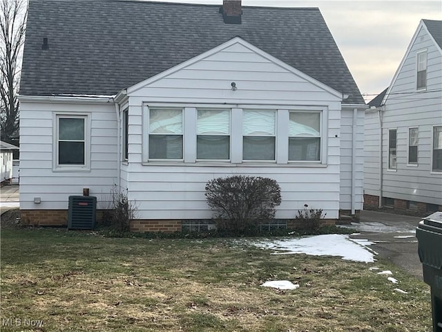 view of side of home featuring a yard and central air condition unit