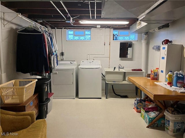 laundry room featuring independent washer and dryer, electric panel, sink, and a wealth of natural light