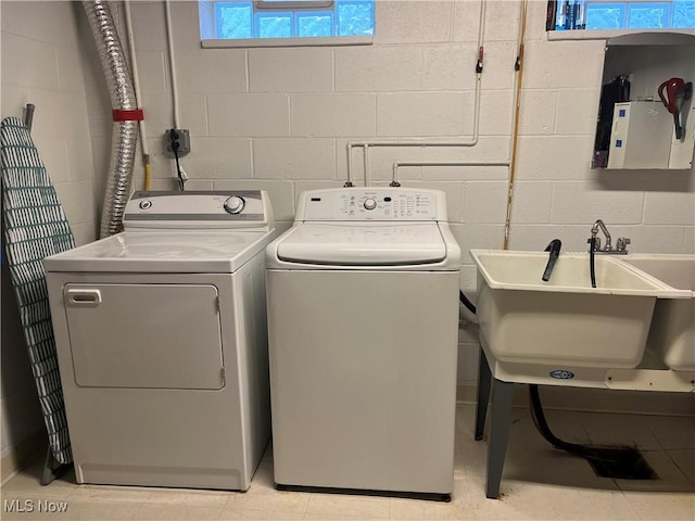 clothes washing area featuring sink and washing machine and clothes dryer