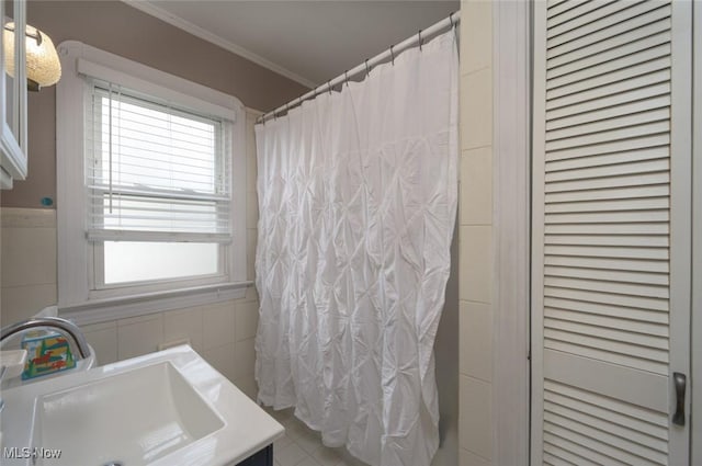 bathroom with walk in shower, ornamental molding, tile walls, and vanity