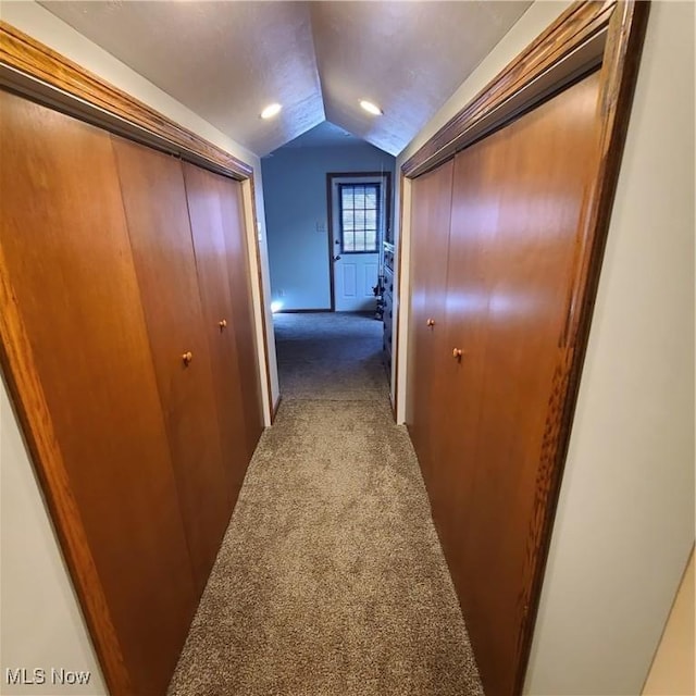 hall with lofted ceiling and carpet