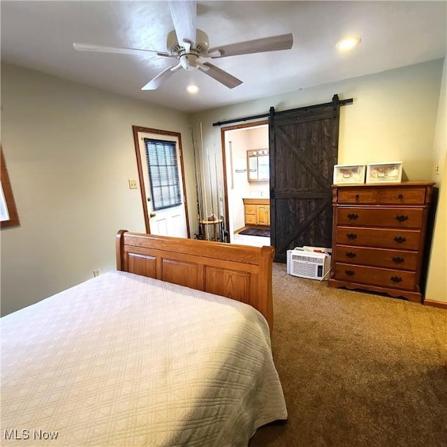 carpeted bedroom featuring ceiling fan, ensuite bathroom, and a barn door