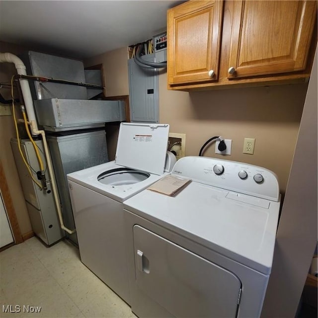 washroom with cabinets, electric panel, and washing machine and dryer