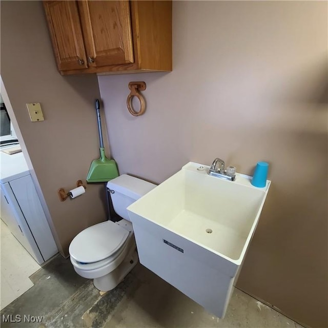 bathroom featuring toilet and washer / dryer