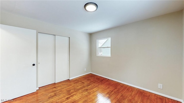 unfurnished bedroom featuring a closet and light wood-type flooring