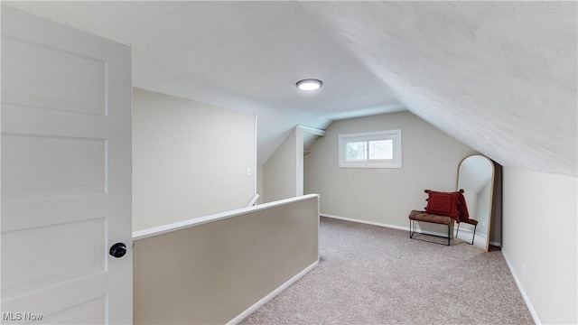 bonus room with lofted ceiling and light carpet