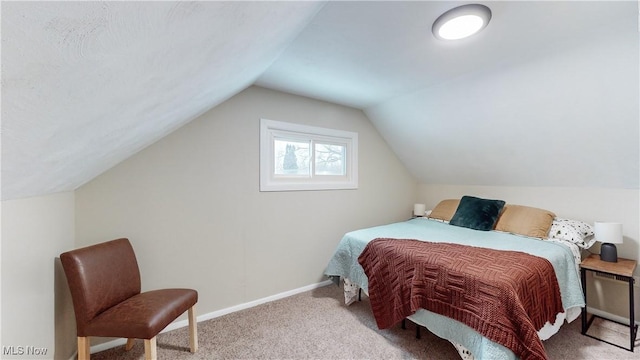 carpeted bedroom with lofted ceiling