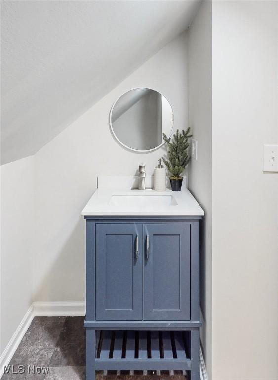 bathroom with vanity and lofted ceiling