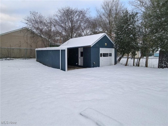 snow covered structure with a garage