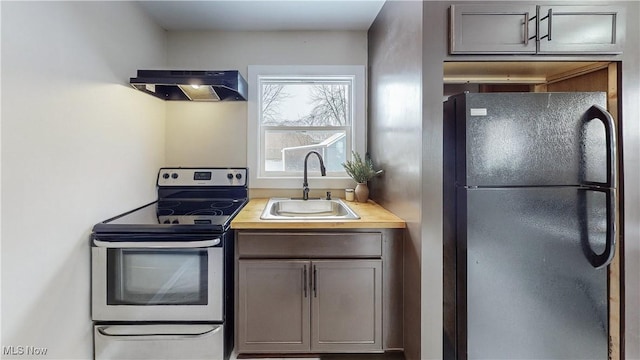 kitchen featuring black refrigerator, stainless steel range with electric stovetop, ventilation hood, and sink