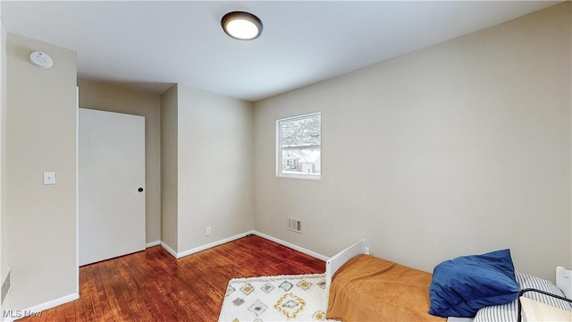 bedroom with dark hardwood / wood-style flooring