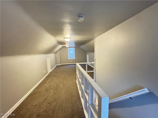 additional living space featuring vaulted ceiling and dark colored carpet