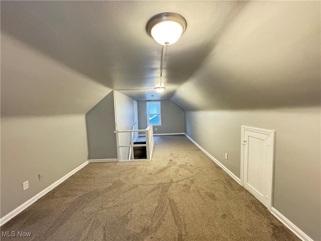 additional living space featuring lofted ceiling and carpet floors