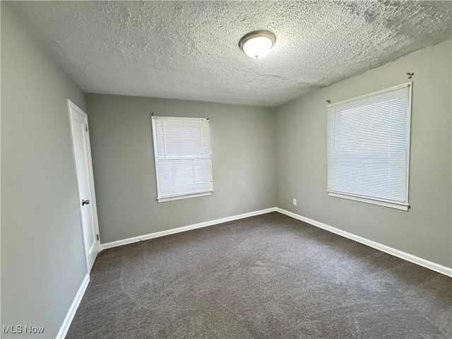 carpeted empty room with a textured ceiling