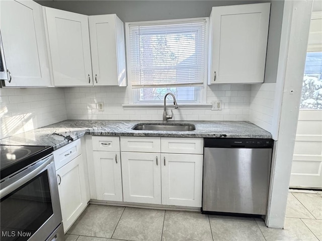 kitchen featuring sink, light stone countertops, white cabinets, and appliances with stainless steel finishes