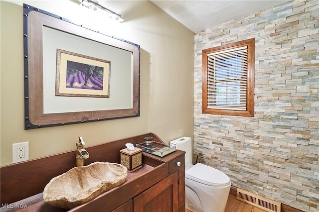 bathroom with hardwood / wood-style flooring, toilet, and vaulted ceiling