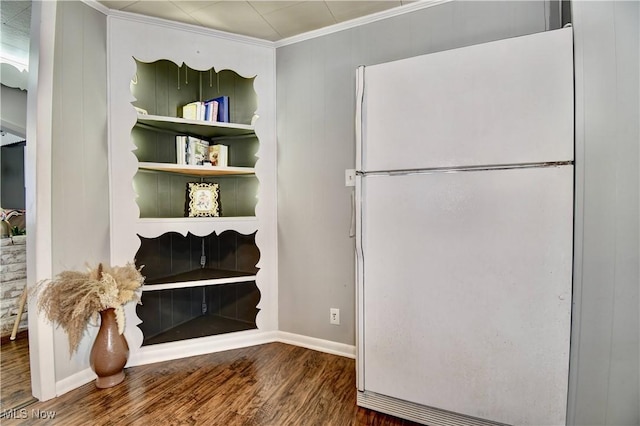 interior space with white fridge, hardwood / wood-style floors, and ornamental molding