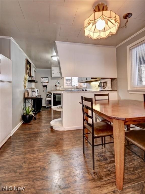 dining room featuring dark hardwood / wood-style floors and ornamental molding