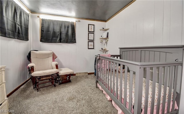 carpeted bedroom with a crib and crown molding