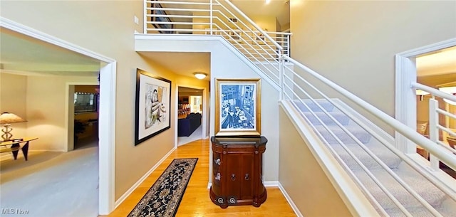 stairs featuring a high ceiling and wood-type flooring