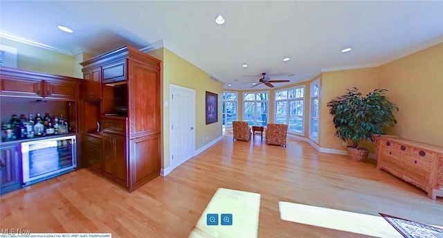 kitchen with light wood-type flooring and crown molding