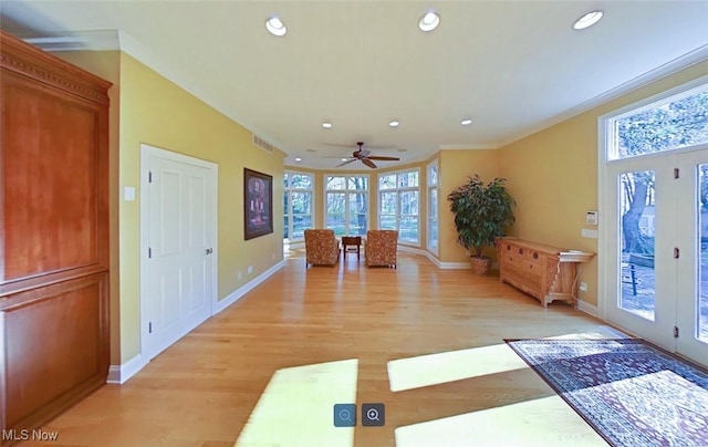 entrance foyer featuring ornamental molding, french doors, and light hardwood / wood-style floors