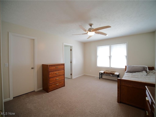 carpeted bedroom with ceiling fan and a textured ceiling