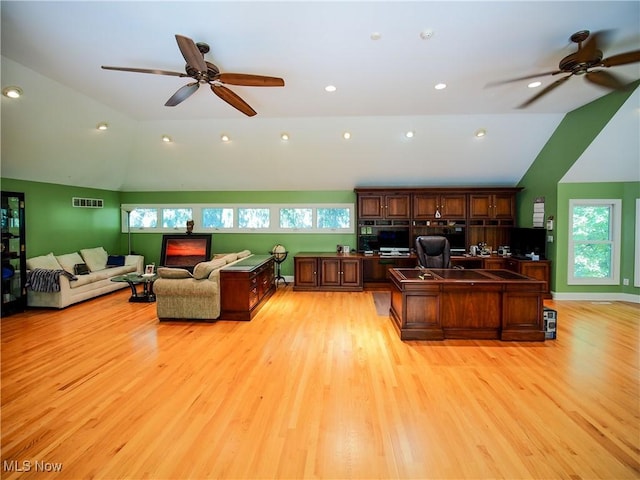 home office featuring vaulted ceiling, ceiling fan, and light hardwood / wood-style flooring