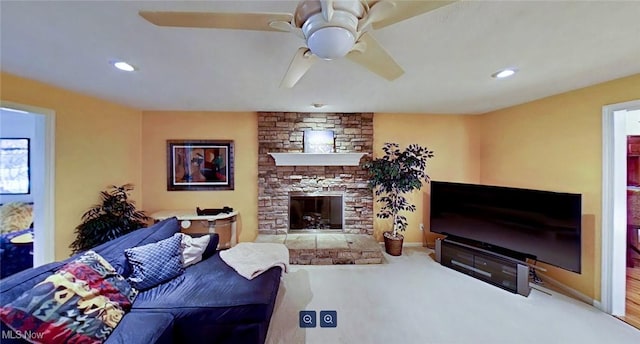 carpeted living room featuring a fireplace and ceiling fan