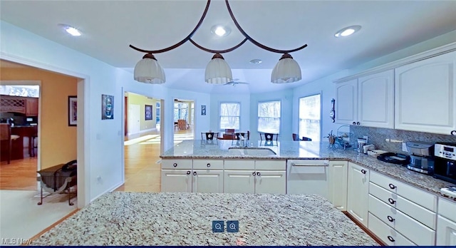 kitchen featuring white cabinets, light stone countertops, sink, and stainless steel dishwasher