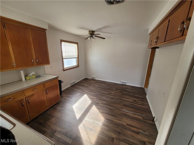 kitchen with ceiling fan and dark wood-type flooring