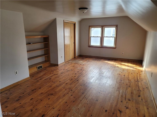 additional living space featuring hardwood / wood-style flooring and lofted ceiling