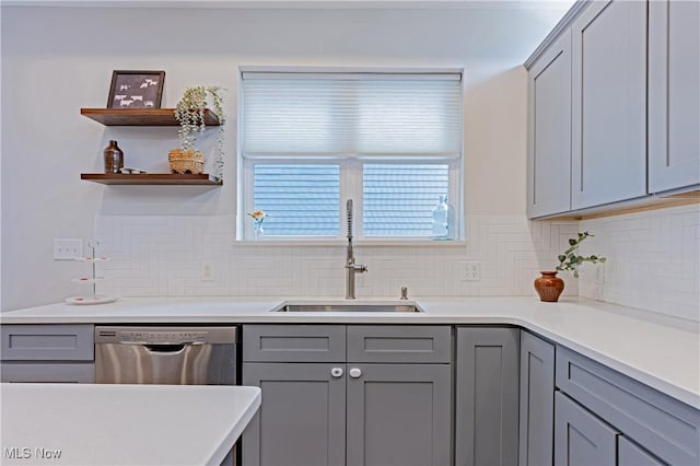 kitchen featuring gray cabinets, dishwasher, tasteful backsplash, and sink