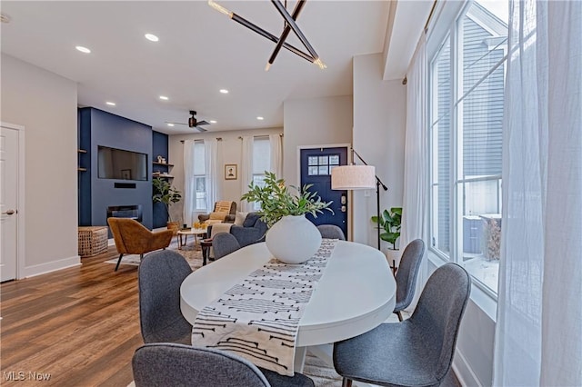 dining area featuring a fireplace, hardwood / wood-style floors, and ceiling fan