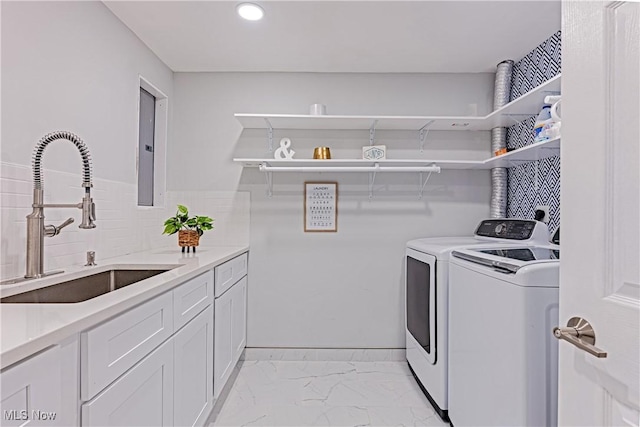 laundry room featuring washing machine and dryer, sink, and cabinets