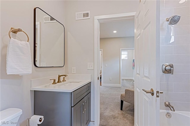 full bathroom with toilet, vanity, and tiled shower / bath