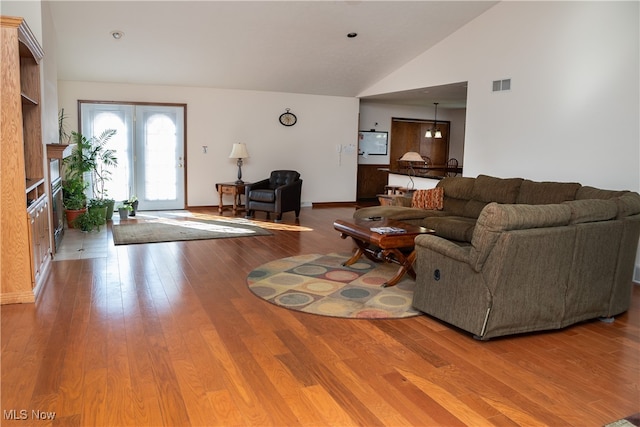 living room featuring high vaulted ceiling and hardwood / wood-style floors